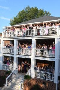 Outdoor shot of the Converse community standing on each balcony of Cudd Hall and waving.